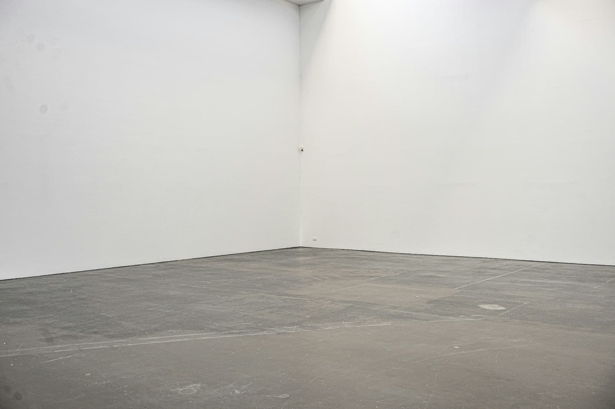 The same style of space cleared out — bare walls and a swept concrete floor